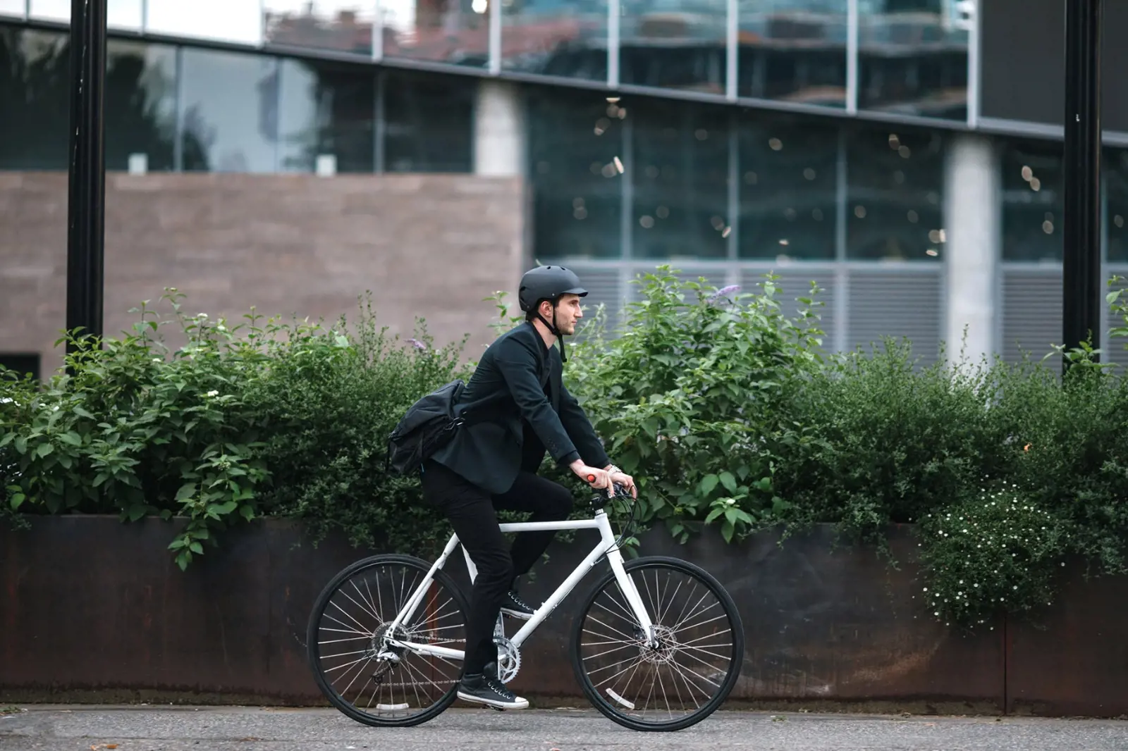 Man cycling outside modern glass building