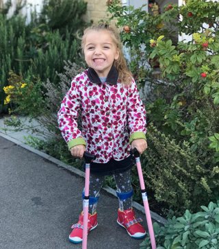 Lilac with her sticks, smiling in garden