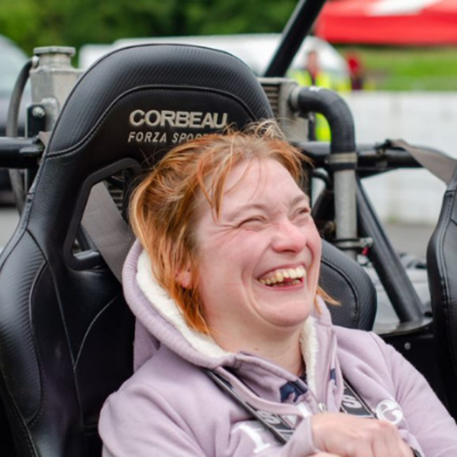 A girl smiling in a Speed of Sight car.